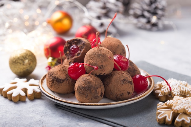 Christmas Sweet candies on the dessert table . Balls of biscuit with cherry - loli pop or cake pop. New year decoration and apple cider drink. happy holidey concept