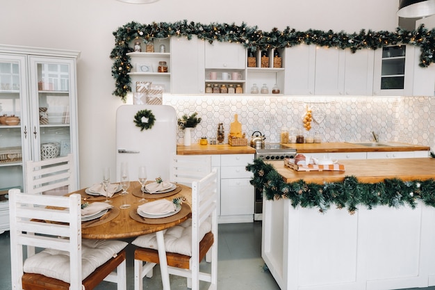 Christmas table decoration in the kitchen, Banquet table with glasses before serving food, close-up of the Christmas dinner table with seasonal decorations, crystal glasses and decorative deer