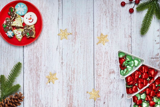 Christmas table decorations with a plate of sugar coated biscuits and chocolate candies.