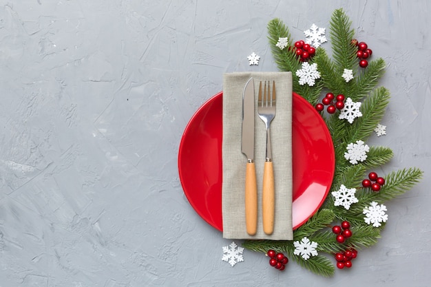 Christmas table place setting with christmas decor and plates, kine, fork and spoon. Christmas holiday background. Top view with copy space