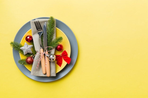 Christmas table place setting with christmas decor and plates, kine, fork and spoon. Christmas holiday background. Top view with copy space