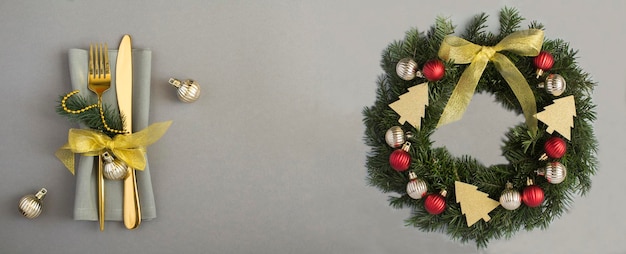 Christmas of table setting and ring or wreath with red and gold balls on the gray background Copy space