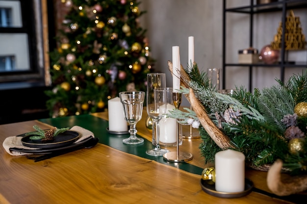 Christmas table setting in rustic style with candles,plates,glasses and eco decors on festive table.