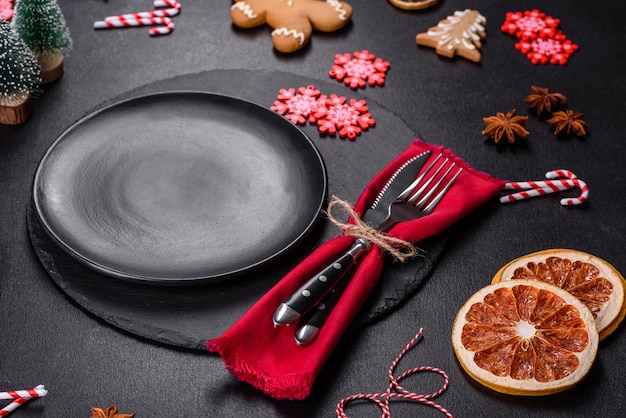 Christmas table setting with empty black ceramic plate fir tree and black accessories