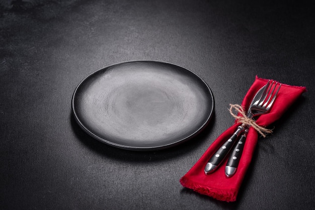 Christmas table setting with empty black ceramic plate fir tree and black accessories