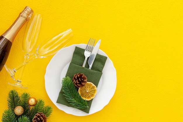 Photo christmas table setting with fir tree and bottle with glasses isolated background