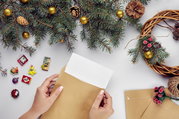 Christmas table with various items womans hands putting a letter in an envelope