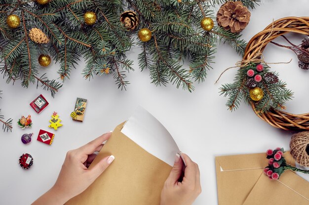 Christmas table with various items womans hands putting a letter in an envelope