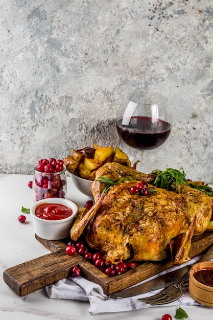 Christmas, thanksgiving food, baked roasted chicken with cranberry and herbs, served with fried vegetables, fresh berries wine and sauces