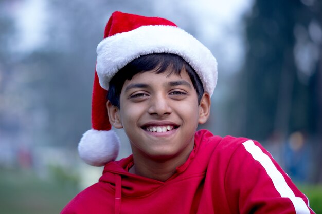 Christmas time - A smiling boy with Santa Claus Hat
  