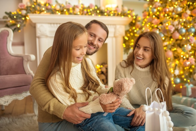 Christmas time. Young parents giving Christmas gift to their daughter