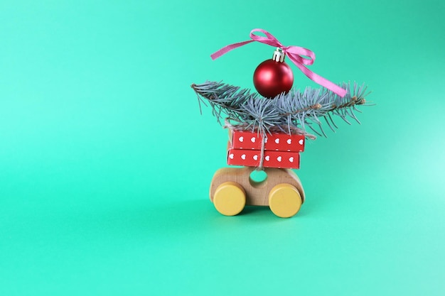 Christmas, a toy car with wrapped gifts and spruce branches, a red ball with a bow