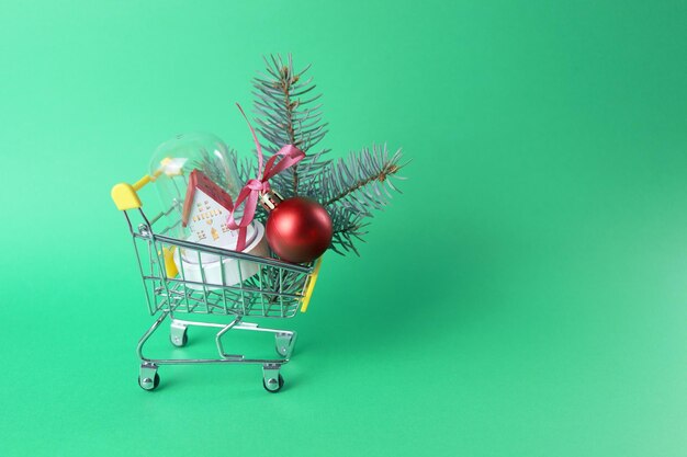 Christmas, a toy cart from a supermarket with a toy car and a small house with illumination