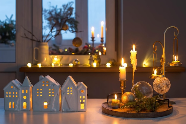 christmas toy houses with burning candles on table