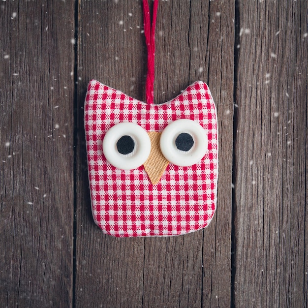 Christmas toy made of cloth owl on a wooden background