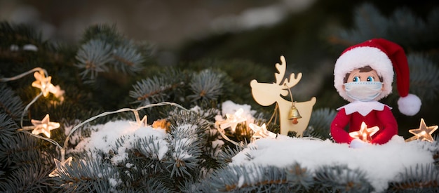 A Christmas toy sits on the branches of a snowcovered Christmas tree with a sparkling star in hands