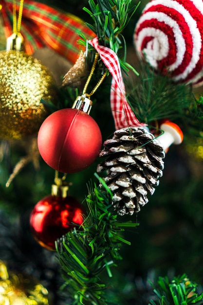 Christmas tree assembled with ornaments. Red, silver and gold balls, gift boxes, lights, Santa Claus and others. Selective focus.