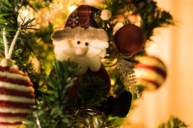 Christmas tree assembled with ornaments. Red, silver and gold balls, gift boxes, lights, Santa Claus and others. Selective focus.