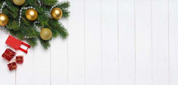 Christmas tree branch decorated with golden balls and decor on white background