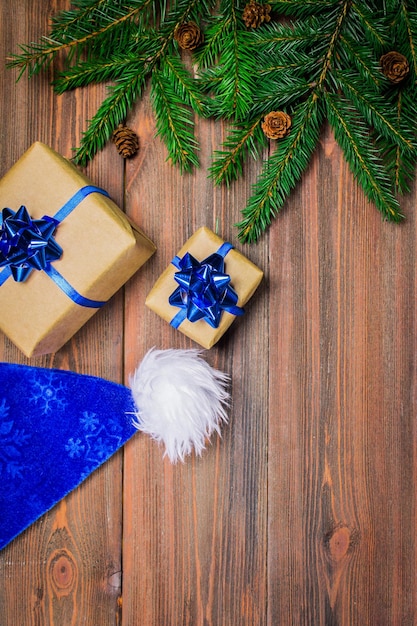 Christmas tree branch gifts on wooden background