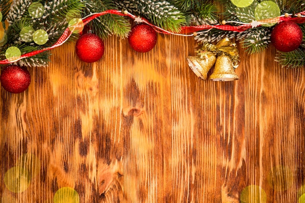 Christmas tree branch with decorations on wood background. Xmas holiday concept