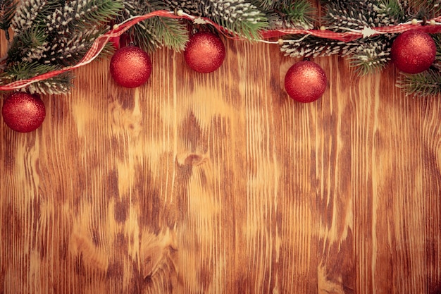 Christmas tree branch with decorations on wood background. Xmas holiday concept