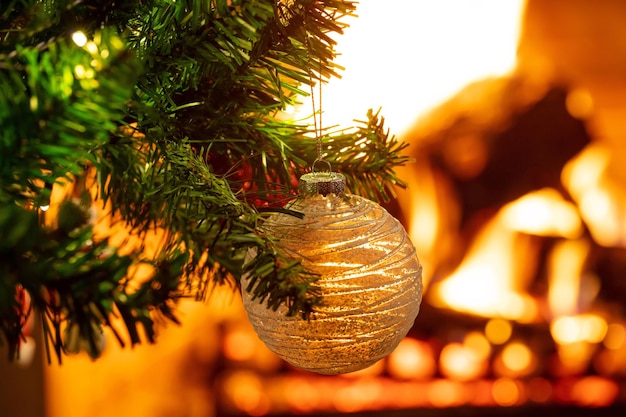 Christmas tree close up on blurred burning fireplace background