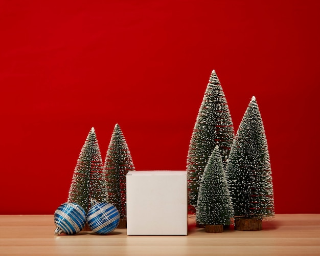 Christmas tree composition gift box Christmas baubles on a wooden table wall red background. for new year or Merry christmas holidays of free space for your decoration Copy space for your text