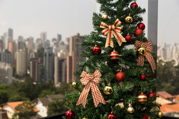 Christmas tree in daylight, with a city landscape