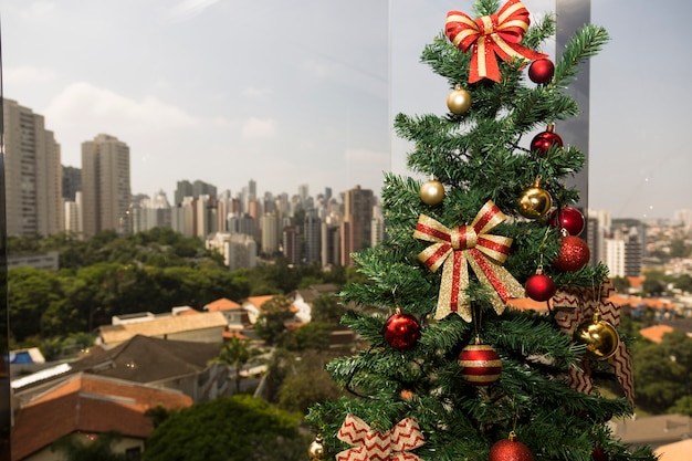 Christmas tree in daylight, with a city landscape