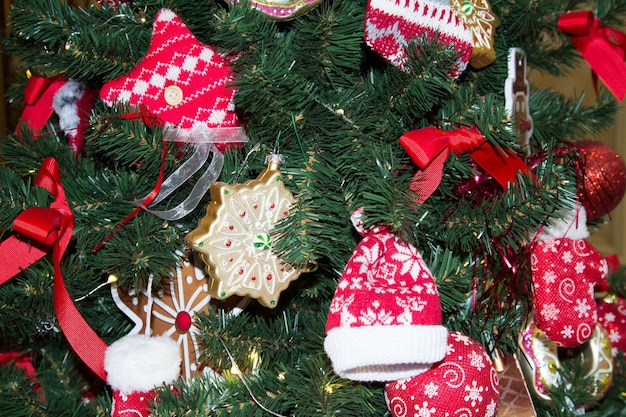 Christmas tree decor closeup with toys in the form of gingerbread and knitted hats