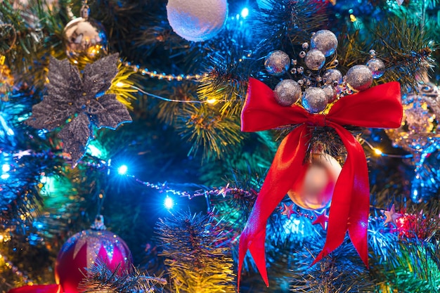 Christmas tree decorated with colorful garlands, toys and balloons close-up. Side view, vertical. Selective focus.