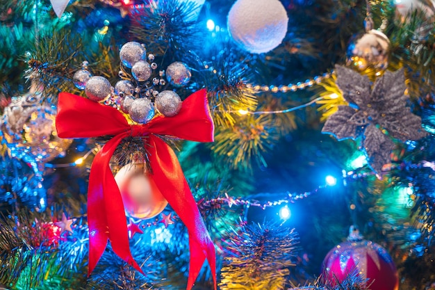 Christmas tree decorated with colorful glowing garlands, toys and balloons close-up. Christmas background. Selective focus.