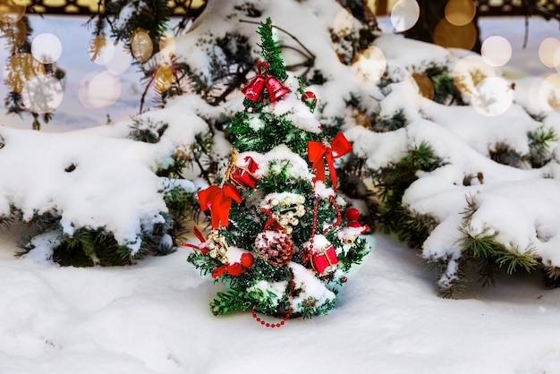 Christmas tree decorated with garlands and toys in the fresh air in the park in winter under snow