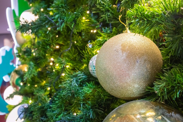 Christmas tree decorated with golden ball on pine branches background