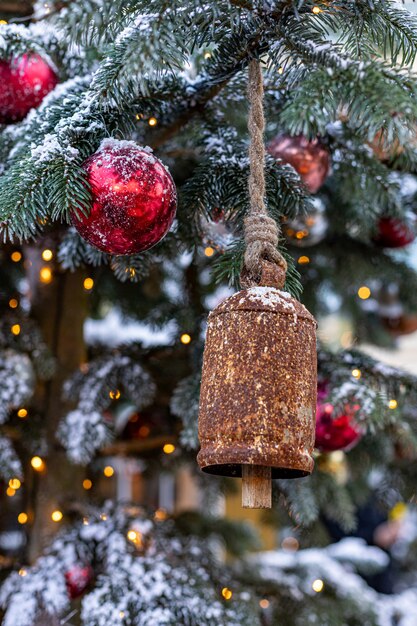 Christmas tree decorated with vintage bells and balls on a blurred abstract sparkling 