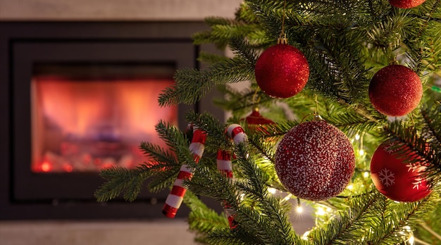 Christmas tree decoration and lights close up view burning fireplace background