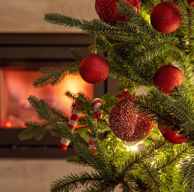 Christmas tree decoration and lights close up view burning fireplace background