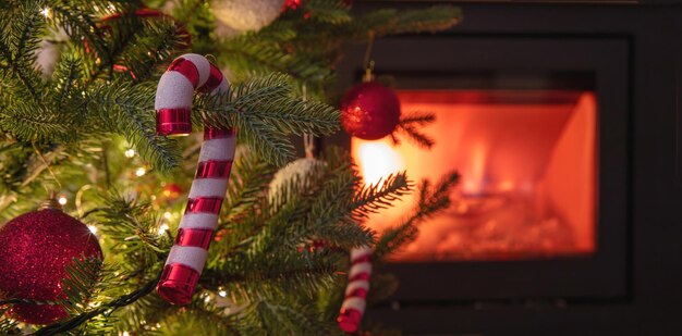 Christmas tree decoration and lights close up view burning fireplace background