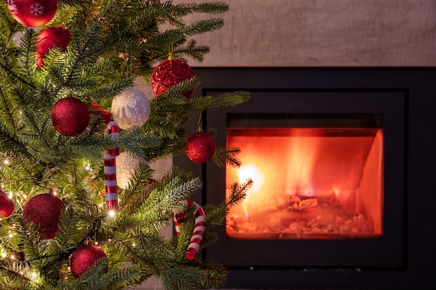 Christmas tree decoration and lights close up view burning fireplace background