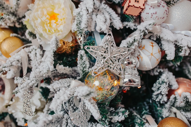 Christmas tree decorations. Different christmas ornaments, angels, balls, snowflakes on the tree. Christmas decorations .