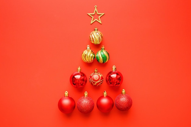 Christmas tree from baubles and golden star on red background