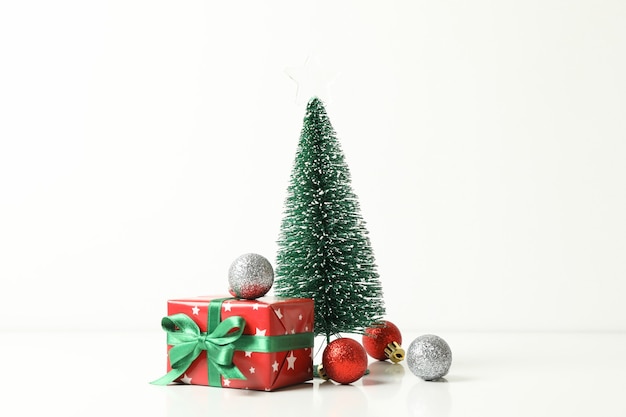 Christmas tree, gift box and baubles on white