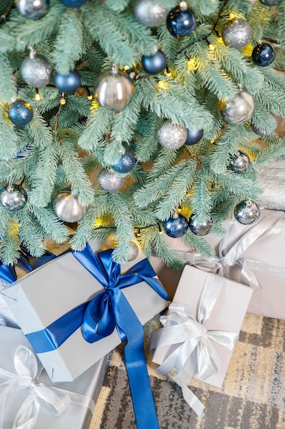 The Christmas tree is decorated with toys and garlands with gifts under it Christmas gifts under the tree