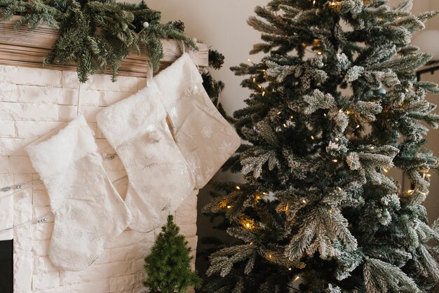 Photo christmas tree is lit up with lights and a fireplace white stockings are hanging on the mantle