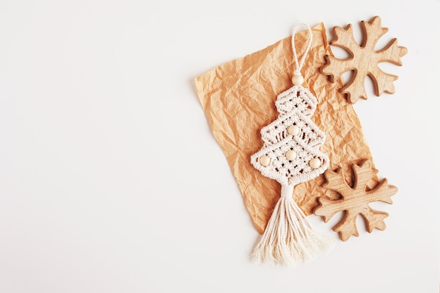 Christmas tree macrame toys on craft papper. White background. Natural materials - cotton thread