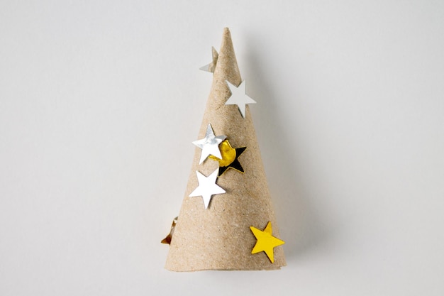 Christmas tree made of cardboard with foil stars made by the hands of a child