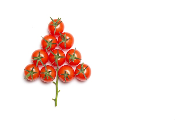 Christmas tree made of cherry tomatoes on a white background. Isolated background.