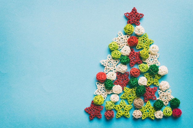 Christmas tree made from colored handmade ball decoration on colored background view from above New Year minimal concept with copy space