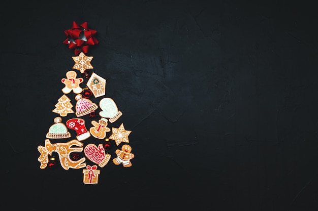 Christmas tree made from gingerbread and spices on a dark background. Copy space. New Year and Christmas greeting card.